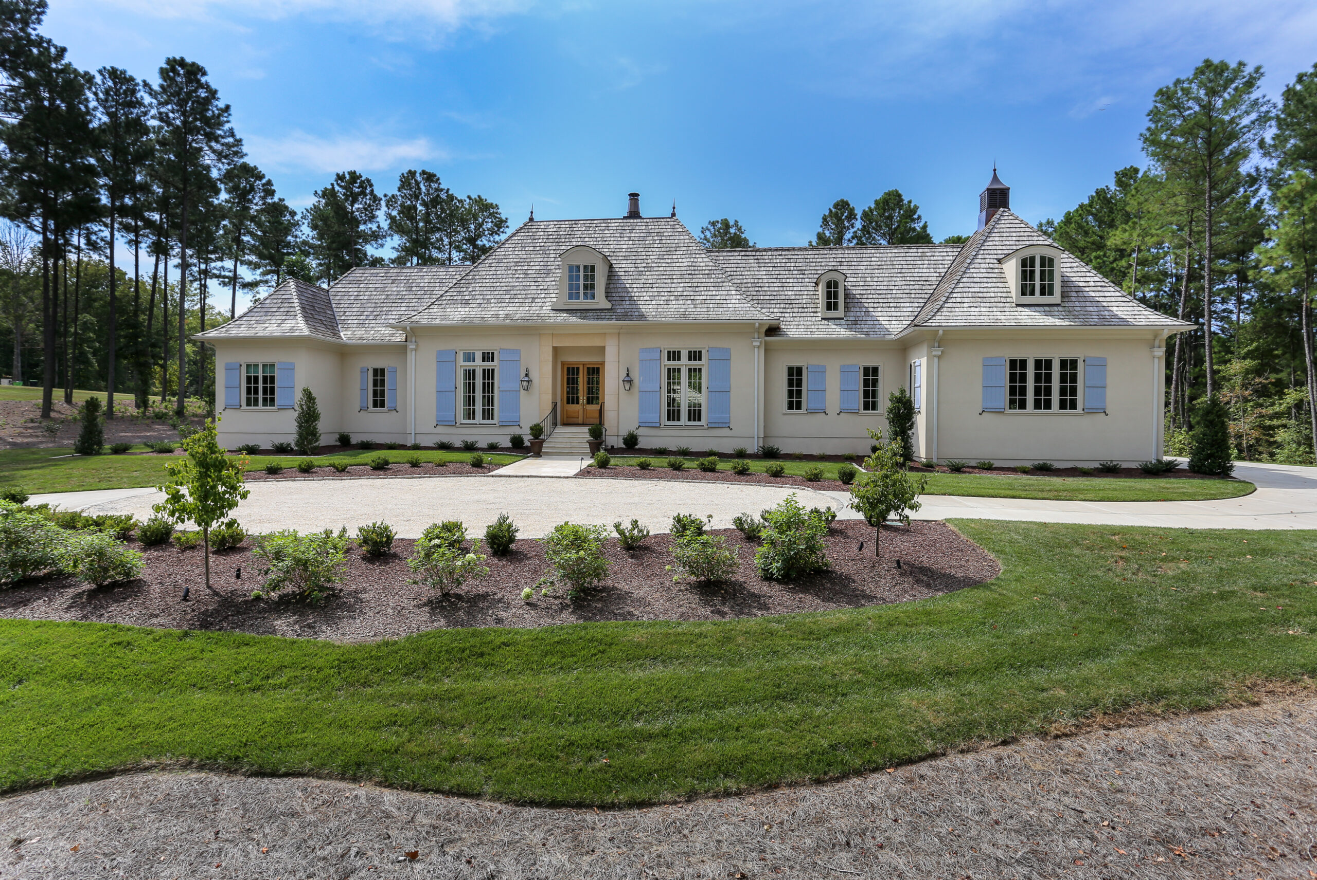 large custom built house with a round about driveway