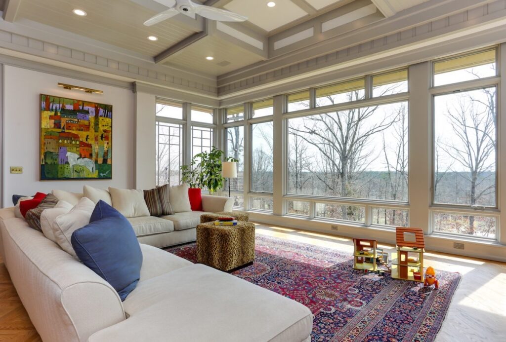 living room of a luxury home remodel with a comfortable couch and large windows 
