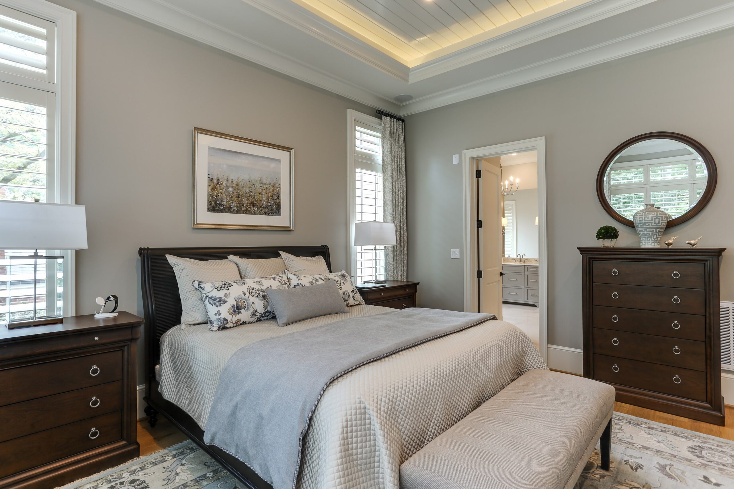 bedroom with gray blanket and brown dressers