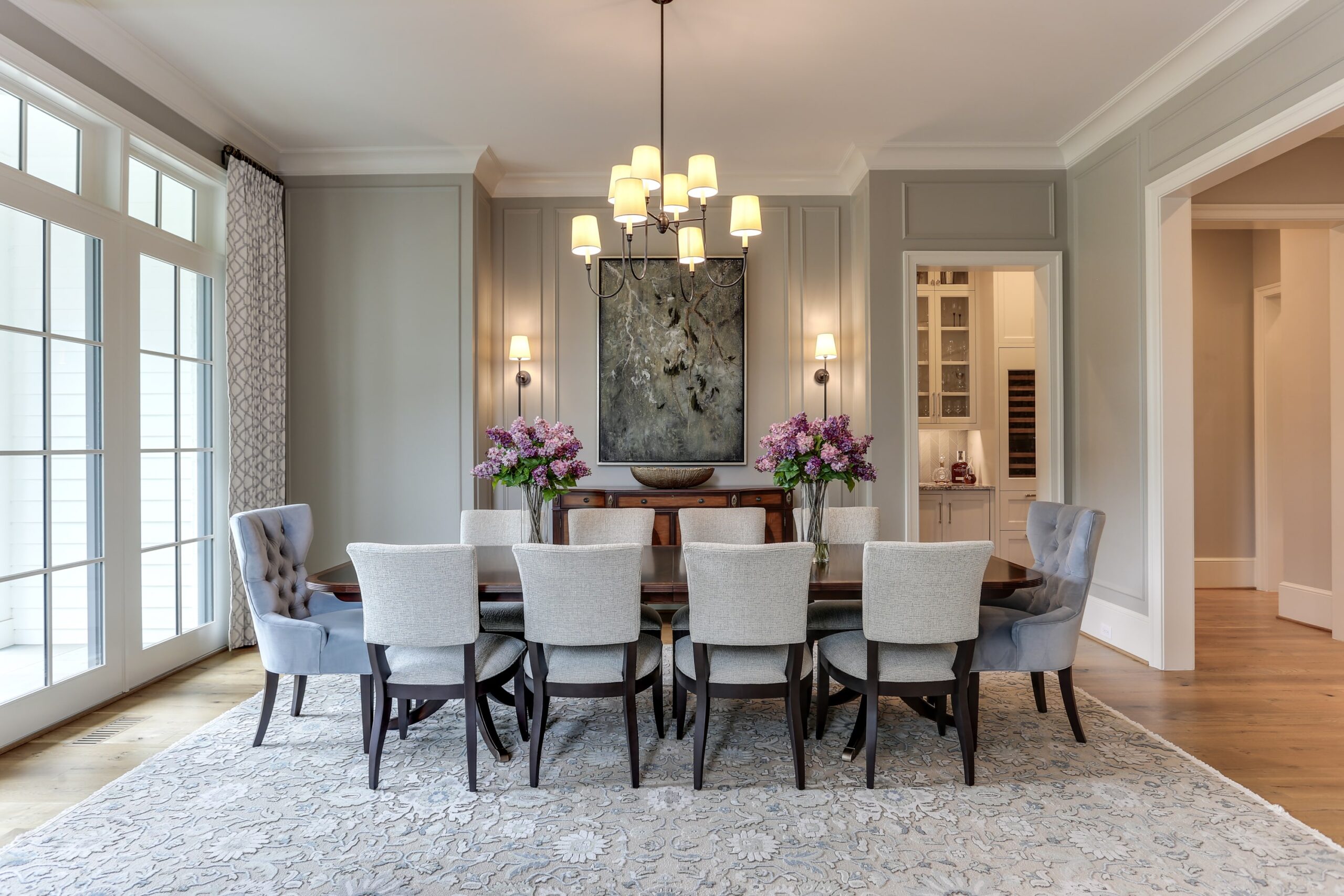 expertly designed dining room with gray seating around a dark wood stained table